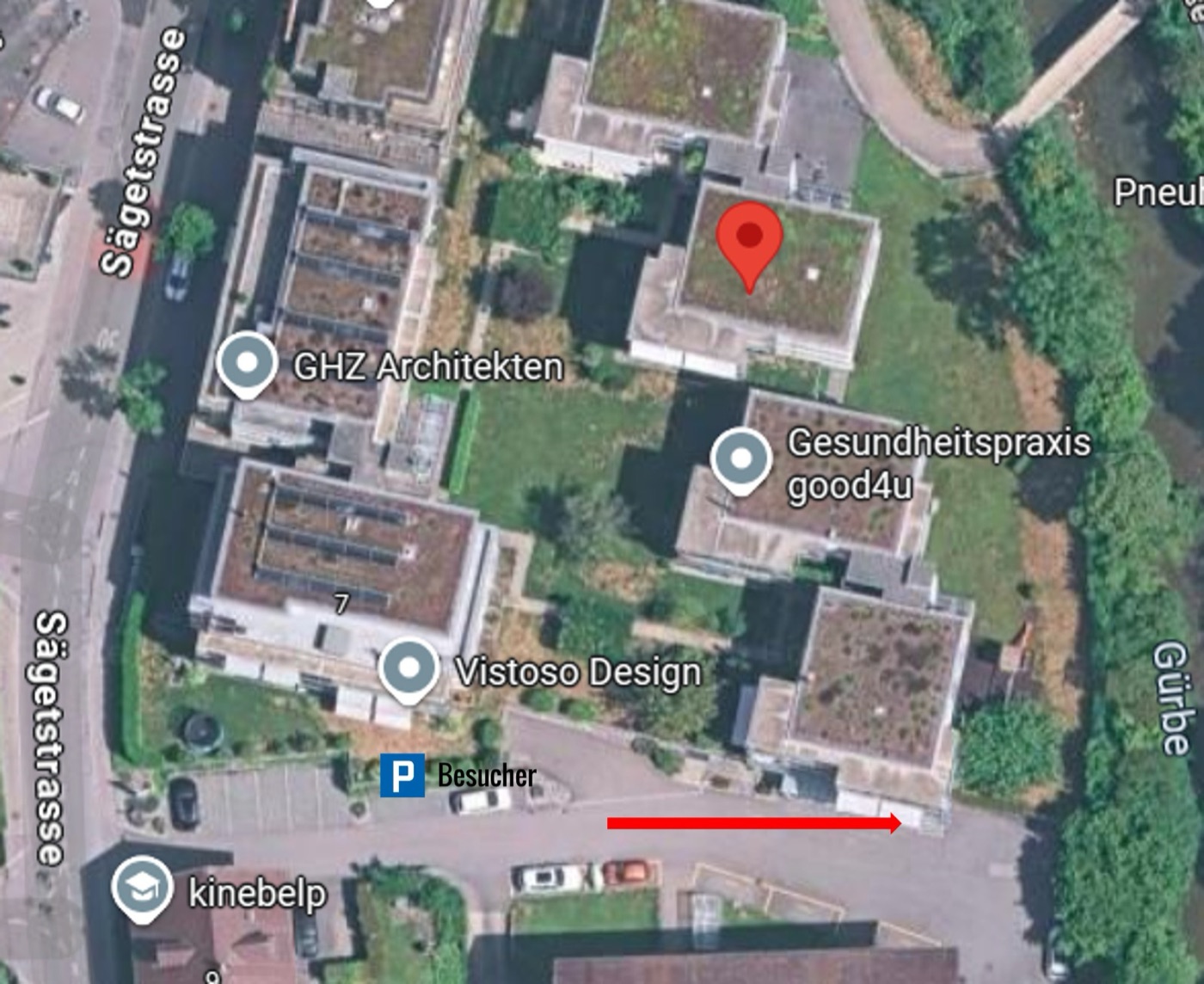 Luftbild: Besucherparkplatz links, dem roten Pfeil der Strasse entlang zum Praxisgebäude folgen